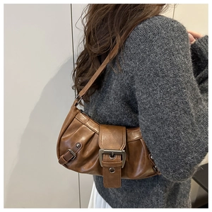Detailansicht der braunen Vintage-Baguette-Tasche mit Faltenoptik und Metallschnalle