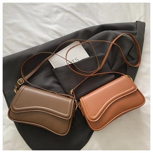 Detailed view of wave-shaped flap edge and matte texture on minimalist crossbody bags
