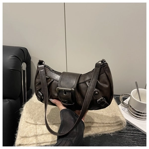 Detail der dunkelbraunen Falten-Hobo-Tasche mit dekorativen Riemen und Silberschnallen