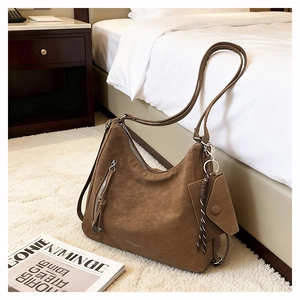 Brown faux suede tote bag with braided details and small pouch on plush rug