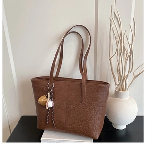 Brown crocodile embossed tote bag with baseball pendant charm and long shoulder handles