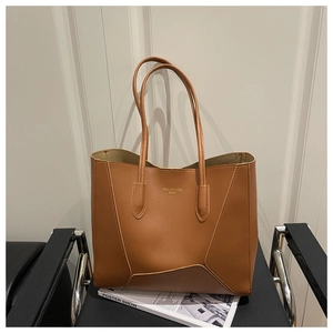 Detailed texture of brown PU leather tote bag with gold lettering on a chair