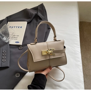 Detail shot of khaki lychee grain leather mini bag with elegant golden lock and strap