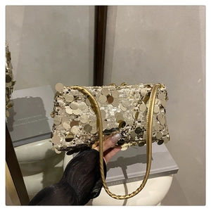Detailed macro view of the gold sequin handbag with cylindrical metallic shoulder strap