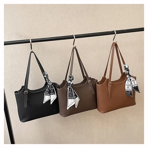Detailed display of three leather tote bags in black and brown with silk scarves on hangers