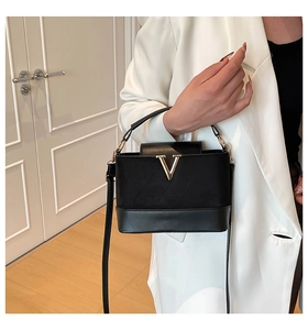 Detail shot of the black suede and leather patchwork crossbody bag with gold V logo