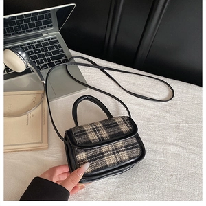 Vue à plat d'un petit sac à carreaux avec garniture en cuir noir et poignée