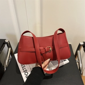 Chic red PU leather baguette shoulder bag with golden buckle on a lifestyle background