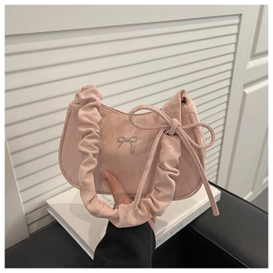 Detailansicht der pinkfarbenen Faltenhandtasche mit Metallschleife und Bandverzierung