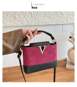 Detailed close-up of a vintage color-block handbag with gold V-logo and red quilted suede
