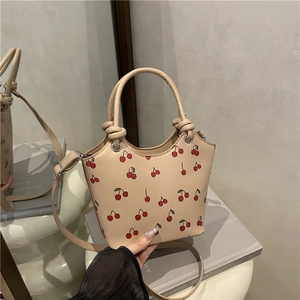 Fashionable beige bucket bag with cute red cherry print and decorative knotted handle