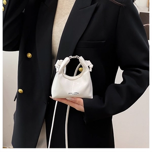 Detail of white glossy mini handbag with silver chain and black HYLLZZA logo