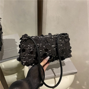 Chic black sequin baguette bag with leather straps on mirror reflecting background