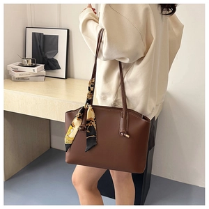 Deep brown tote bag detail with printed silk scarf and white contrast stitching