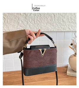 Detail of coffee brown crossbody bag with metal V-logo and quilted suede texture