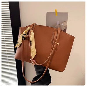 Detail of deep brown PU tote bag featuring decorative silk scarf and contrast stitching