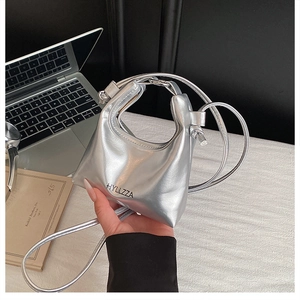 Close-up of metallic silver mini handbag with black lettering and a slender shoulder strap