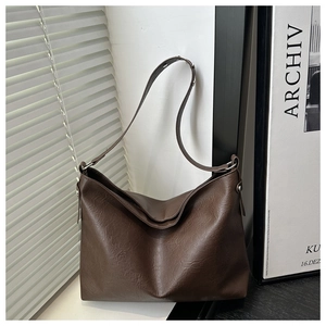 Detail of soft dark brown leather tote bag with elegant shadow on a minimalist background