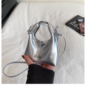 Detail of silver metallic PU leather mini handbag with HYLLZZA logo and thin strap