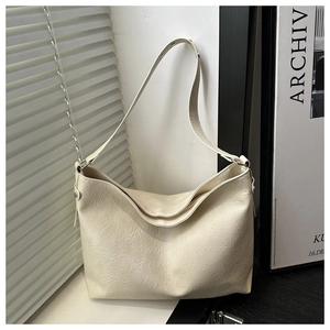Close-up of cream white tote bag showing the soft faux leather texture and pleated details