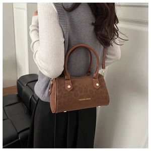 Détail d'un sac baril imprimé léopard marron avec des détails dorés élégants