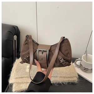 Détails d'un sac sous les aisselles marron foncé rétro avec boucles et texture plissée