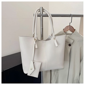 Detail of cream white leather tote bag with matching envelope pouch and stitching