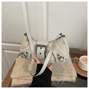 Détail du sac à bandoulière en cuir beige clair avec boucle et texture plissée