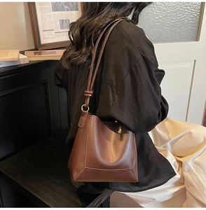 Detail of vintage brown leather tote bag showing fine stitching and gold hardware