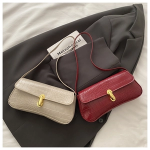 French retro crocodile pattern handbags with gold buckles on a grey blazer backdrop