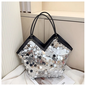 Detail of silver sequin tote bag featuring black leather handles and V-shaped top cutout