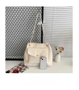 Detailed comparison of off-white tote bag size relative to a smartphone with gold hardware