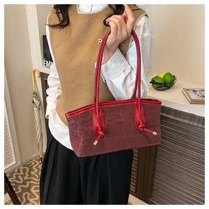 Close-up of burgundy tote bag with leopard print texture and knotted handle detail
