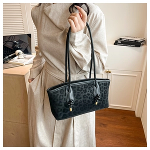 Close-up of leopard print tote bag with thin leather straps and metallic drawstring detail