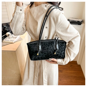 Detail of leopard print shoulder bag with black leather strap and golden zip hardware
