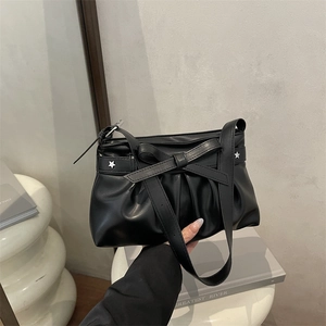 Schwarze Schultertasche mit Schleife, Sternennieten und Falten-Textur im minimalistischen Look