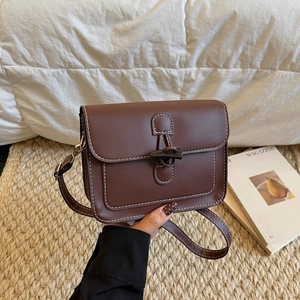 Vintage dark brown leather crossbody bag with toggle closure and white stitching detail