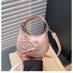 Gros plan du sac lune rose avec des nœuds décoratifs et une texture en similicuir brillant