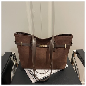 Detail of dark brown suede tote bag with metal buckle strap and smooth leather handle