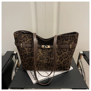 Detail of leopard print tote bag with brown leather strap and golden metal buckle