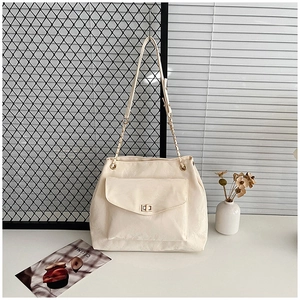 Close-up of cream white pleated PU leather tote bag with gold chain and metal lock