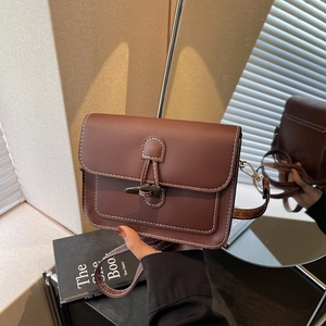 Vintage brown leather crossbody bag with white contrast stitching and horn buckle detail