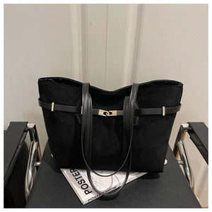 Detailed view of black suede tote bag with decorative leather belt and gold buckle