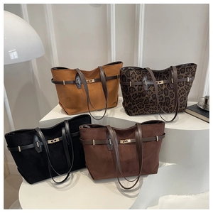 Four suede tote bags in camel, brown, leopard, and black with gold lock details