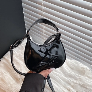 Sac à main croissant en cuir verni noir avec nœuds doux et bandoulière chaîne argentée