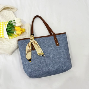 Blue denim tote bag with brown leather handles and decorative silk scarf for women