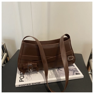 Close-up of vintage dark brown leather shoulder bag with metallic buckle and bow detail