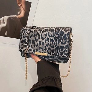 Leopard print crossbody bag with gold chain strap and metal trim in a modern style