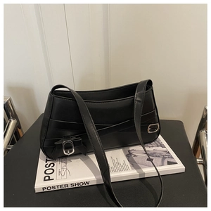 Close-up of minimalist black matte leather shoulder bag with silver buckle details