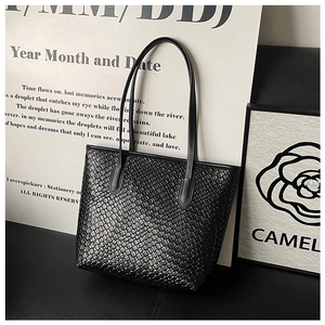 Macro detail of the premium black woven texture on this stylish minimalist tote bag